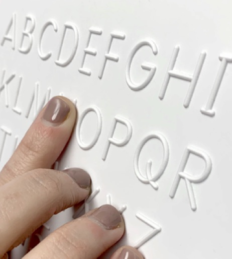 photo of fingers reading rounded sample letters